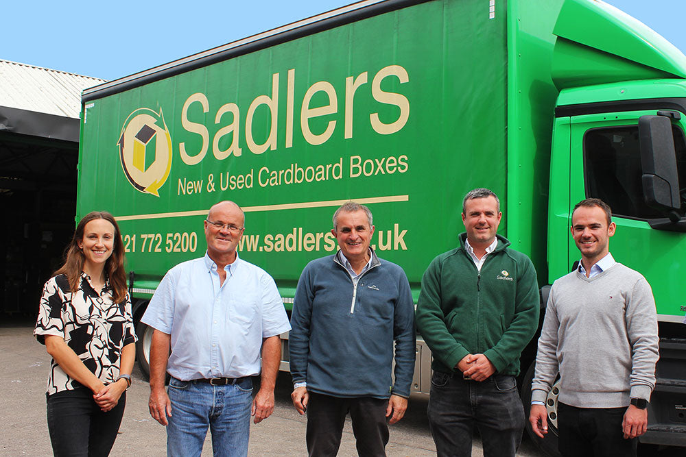 team photo of Lauren, Rob, Mike, Gavin and Jordan in front of a Sadlers lorry